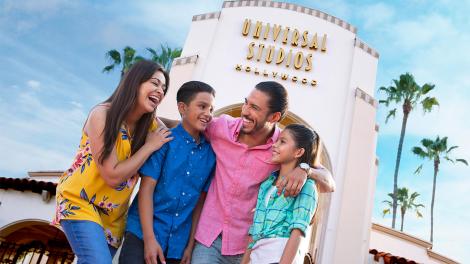 加利福尼亚州好莱坞环球影城的标志性球形标志前，一家人正在拍照