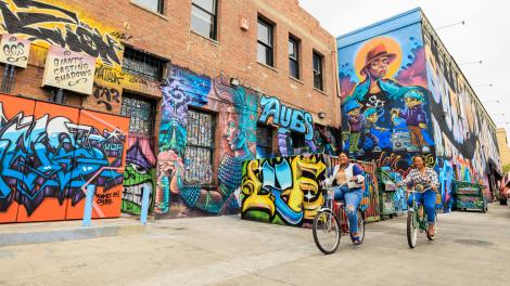 骑行者经过圣安娜市中心多彩的壁画 骑行者经过圣安娜市中心多彩的壁画