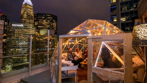 在北卡罗来纳州夏洛特 Merchant & Trade 餐厅享受屋顶欢乐时光，欣赏夏洛特市中心美景