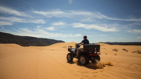 Driving an atv in Coral Pink Sand Dunes State Park in Kane County, Utah