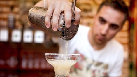 男人倒出调酒器的鸡尾酒 男人倒出调酒器的鸡尾酒