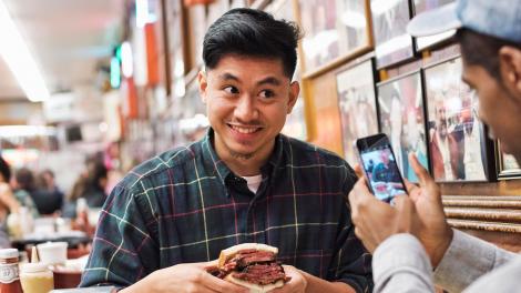 在纽约市著名的 Katz's Delicatessen 熟食店内咬一口美味的三明治 在纽约市著名的 Katz's Delicatessen 熟食店内咬一口美味的三明治