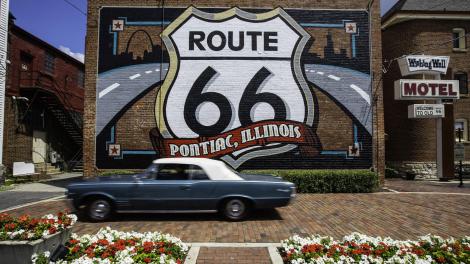 一辆复古的庞蒂克驶过66号公路标志