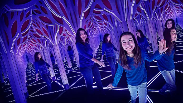 正在科学与工业博物馆内探索穿越镜子迷宫的参观者 正在科学与工业博物馆内探索穿越镜子迷宫的参观者