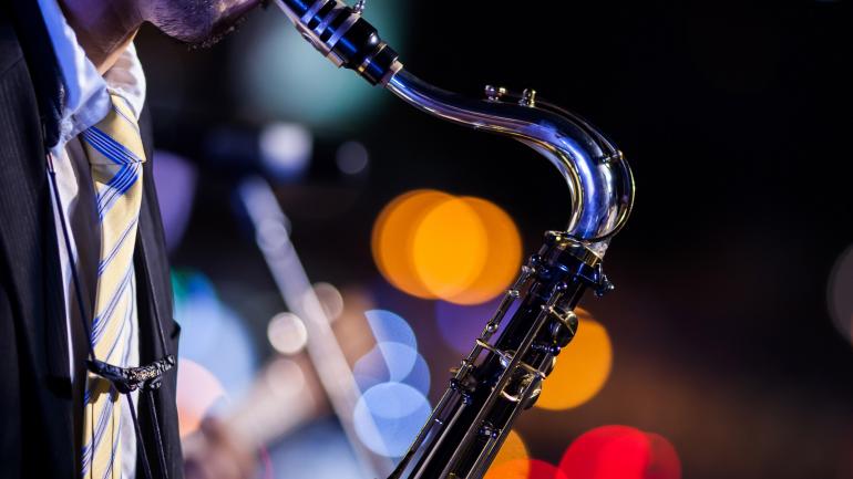 一个人在 Snug Harbor Jazz Bistro 爵士酒吧的现场爵士表演中吹奏萨克斯 一个人在 Snug Harbor Jazz Bistro 爵士酒吧的现场爵士表演中吹奏萨克斯