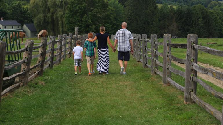 一家人在比林斯农场博物馆的农场里散步