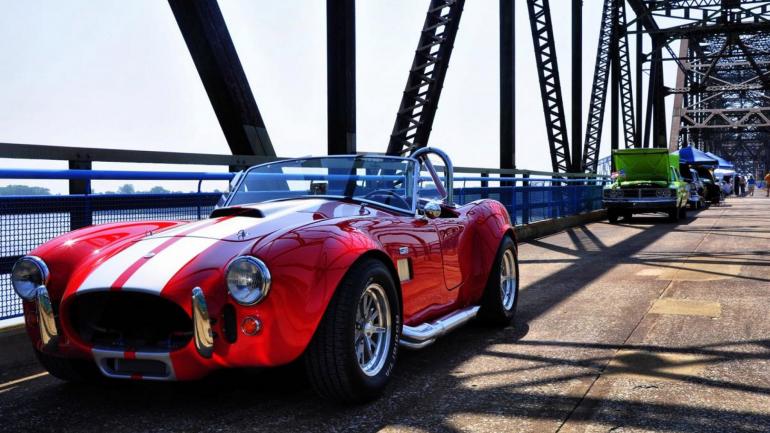 一辆老爷车驶过石链桥