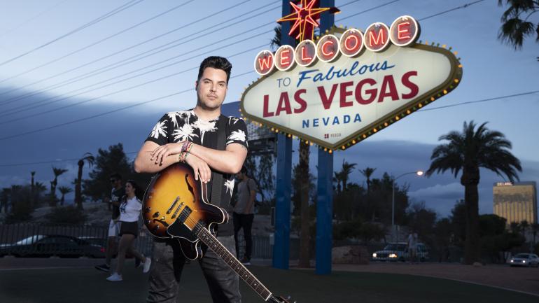 在著名的拉斯维加斯标志旁摆姿势拍照留念的 Moreno