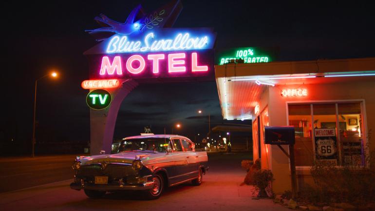 新墨西哥州图克姆卡里的 Blue Swallow Motel 汽车旅馆外有一辆老式汽车和标示旅馆名称的霓虹灯 新墨西哥州图克姆卡里的 Blue Swallow Motel 汽车旅馆外有一辆老式汽车和标示旅馆名称的霓虹灯