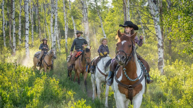 A family trail ride at a Colorado dude ranch A family trail ride at a Colorado dude ranch