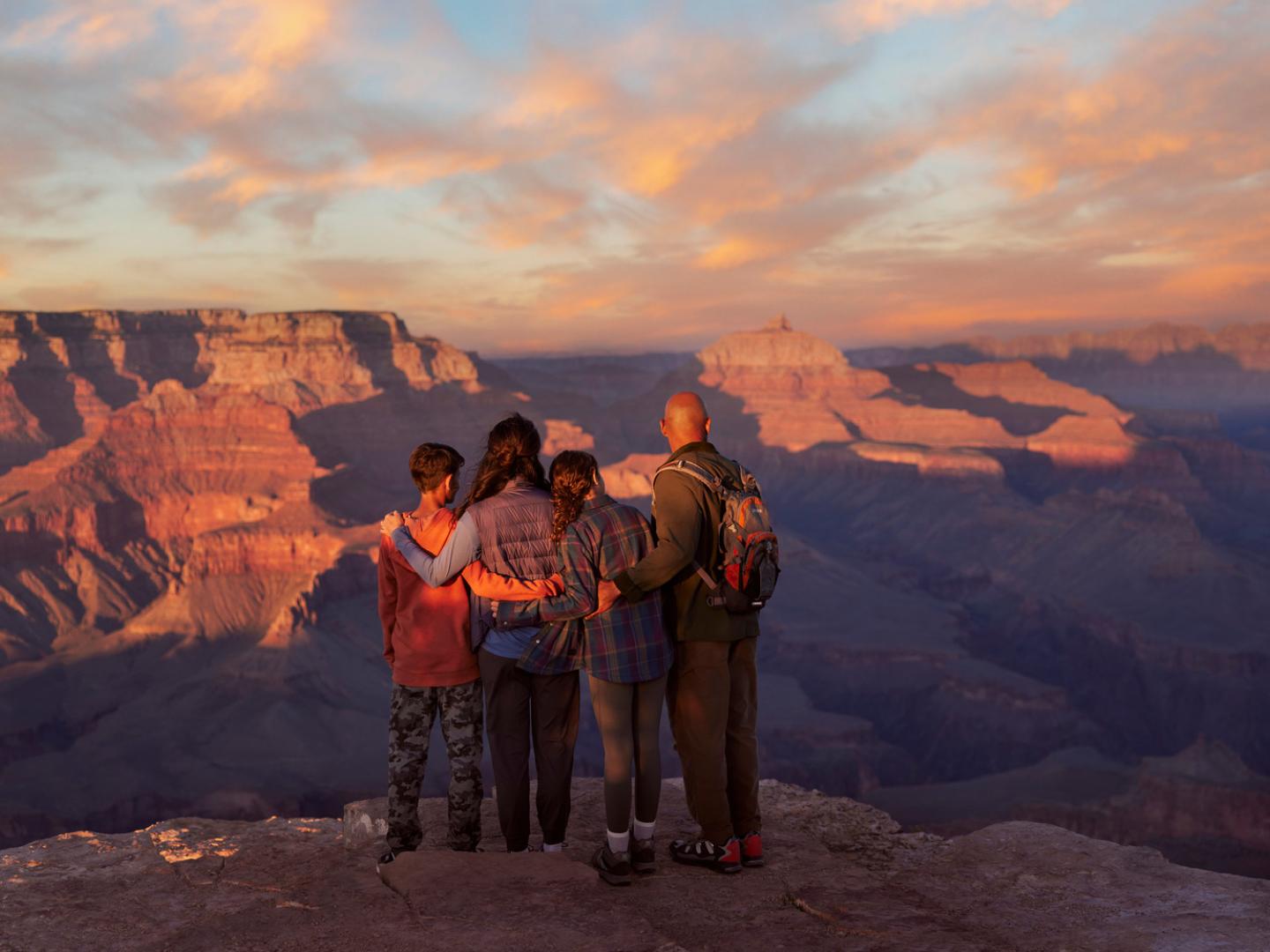 一家人在亚利桑那州大峡谷国家公园的一处观景台上欣赏开阔壮丽的大峡谷风光 一家人在亚利桑那州大峡谷国家公园的一处观景台上欣赏开阔壮丽的大峡谷风光