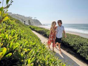 一对爱侣沿着小径漫步，从这里可以眺望盐溪海滩