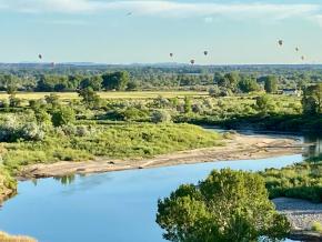 在一年一度的里弗顿会合点热气球大会上，热气球在风河上空徐徐升起