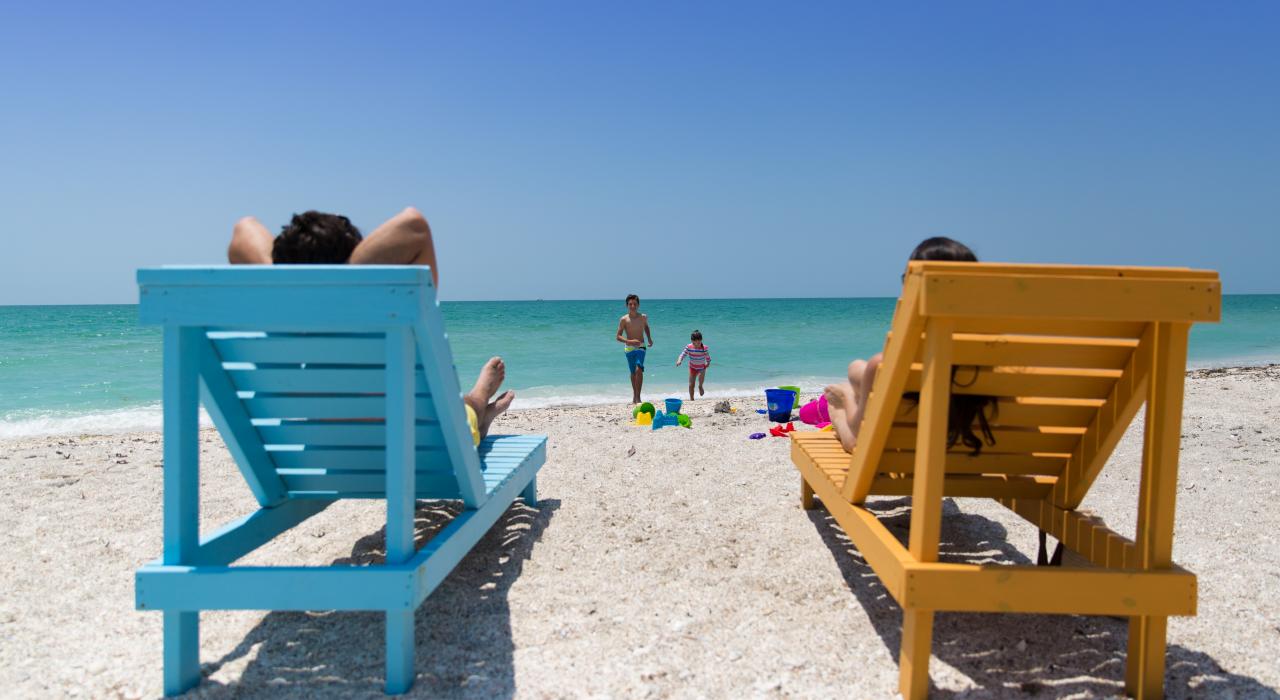 在海滩边色彩缤纷的躺椅上休闲放松