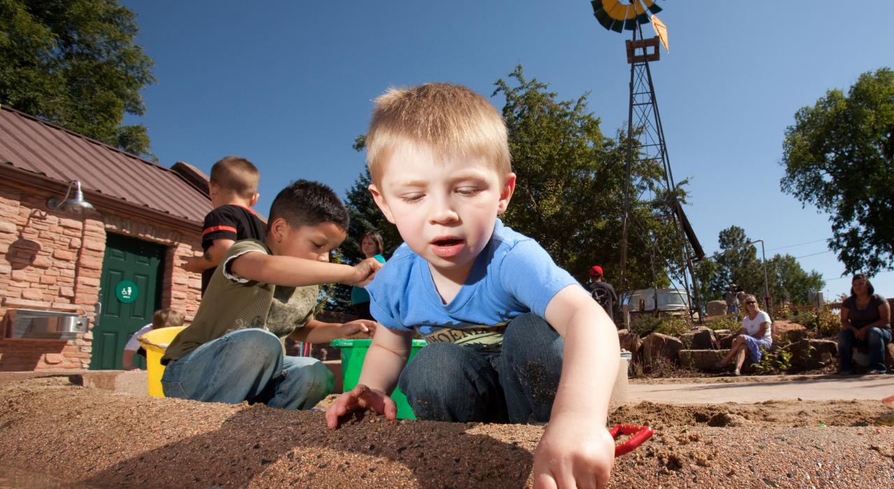 在夏安植物园（Cheyenne Botanic Gardens）的儿童村里挖沙子