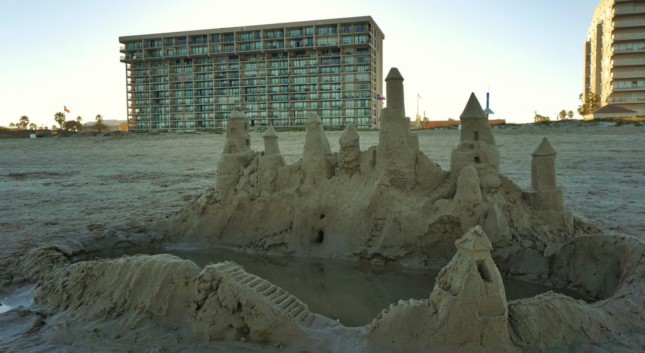 Sandcastle handiwork washing away on the beach