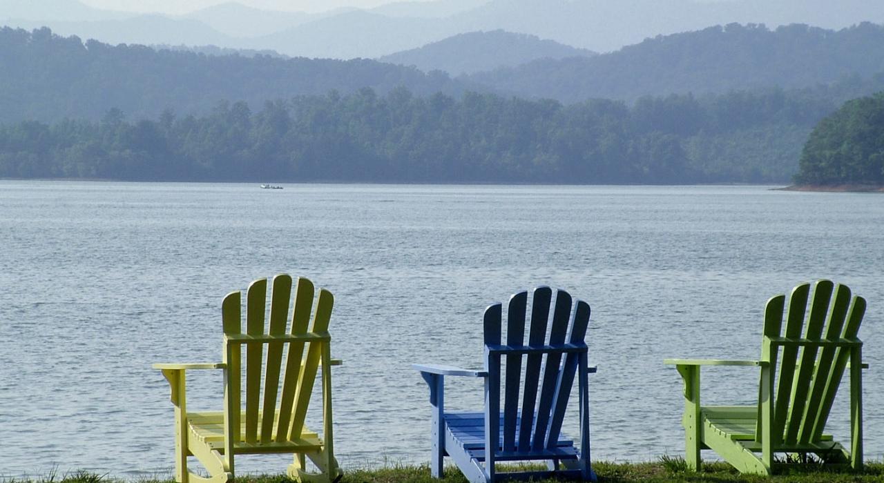 一个夏日午后摆放在湖边的彩色座椅