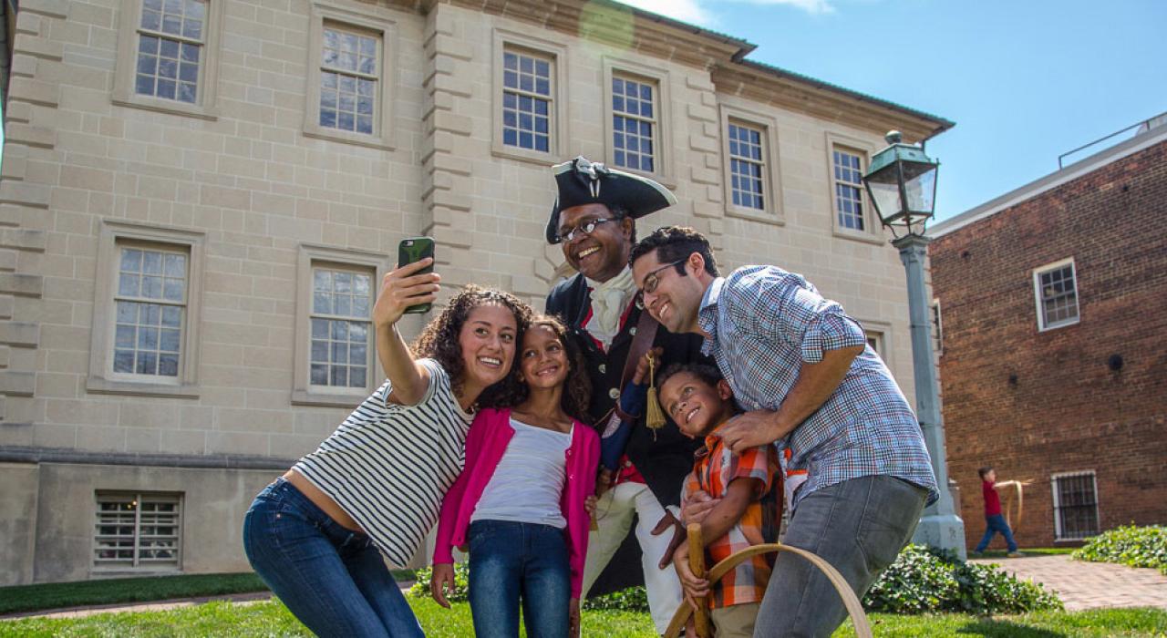Taking a family selfie with a constumed reenactor at one of the city's many early American museums and historic sites