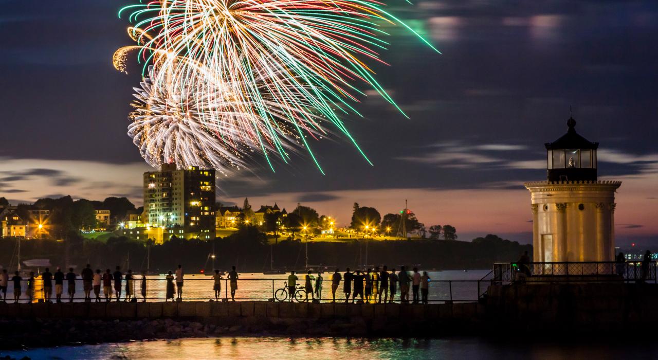 海港边聚集的人们愉快地观赏烟火表演