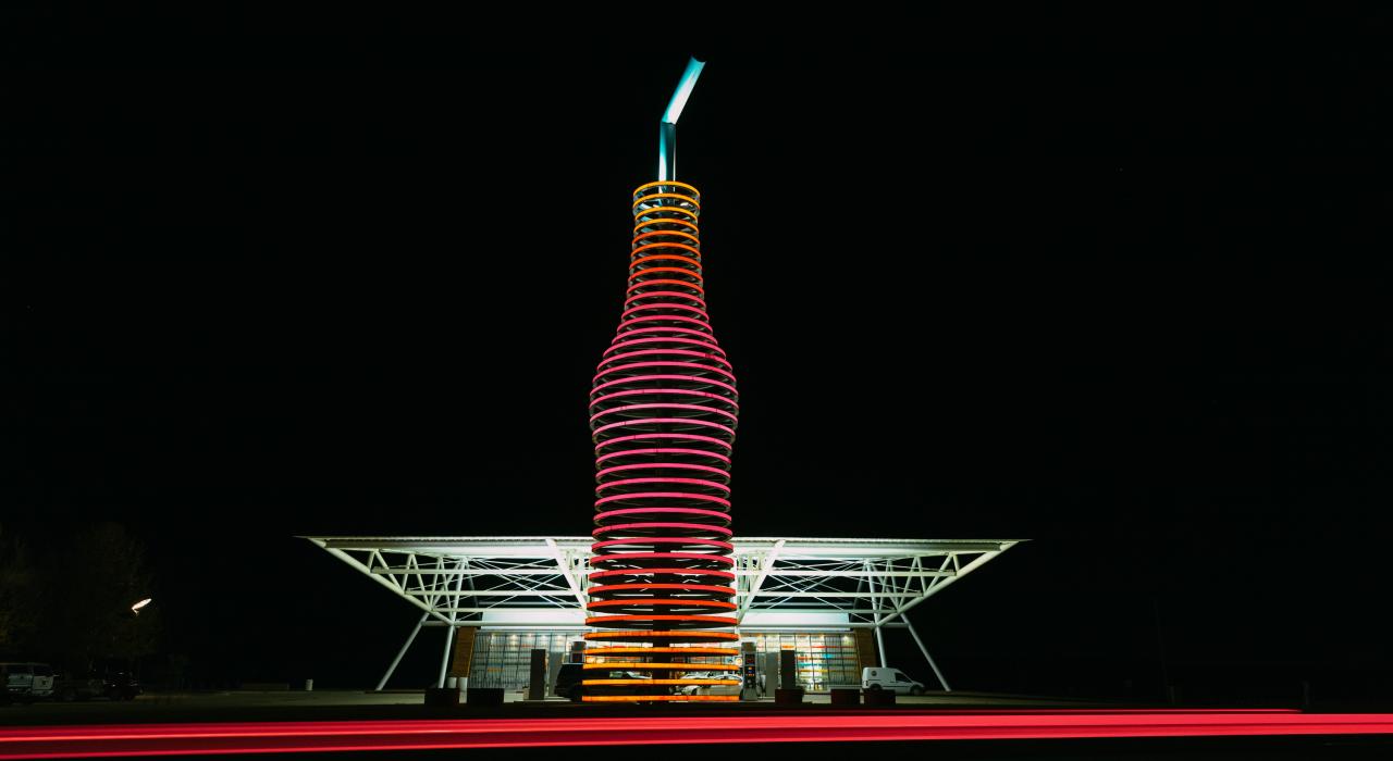 夜色中，俄克拉荷马州阿卡迪亚 Pops 66 Soda Ranch 餐厅外的巨型发光苏打水瓶雕塑