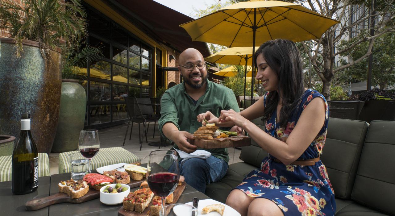 在亚利桑那州坦佩市中心的 Postino Annex 餐厅无忧无虑地享用午餐开胃菜和葡萄酒