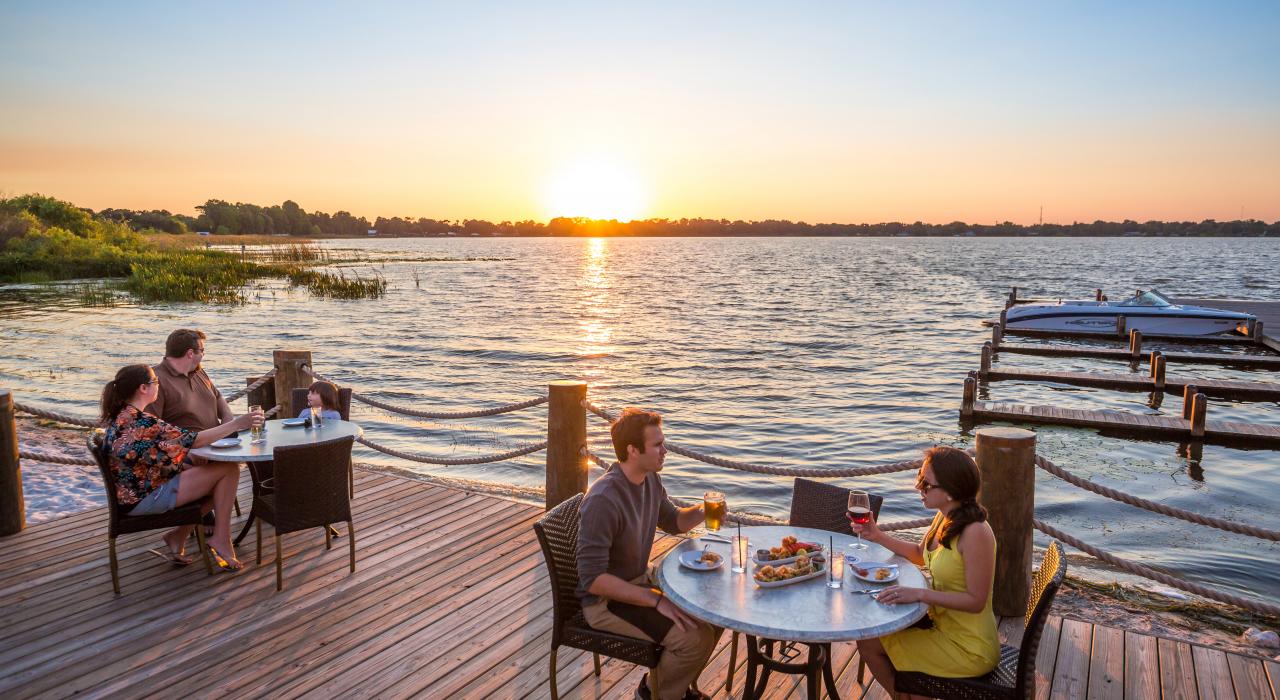 日落时分在佛罗里达州中部的某个湖畔，伴着美景享用美食