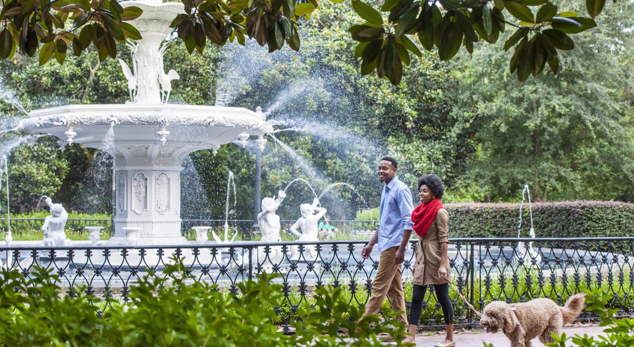 佐治亚州萨凡纳，夫妻俩遛狗经过福赛斯公园的标志性喷泉