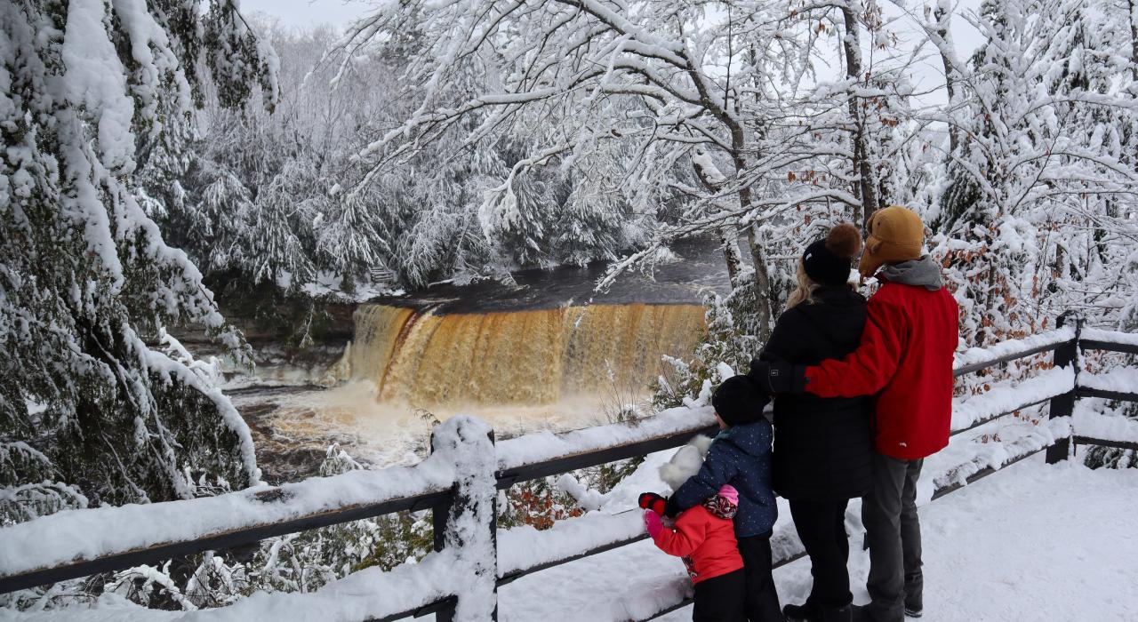一家人在冬天欣赏塔库梅隆瀑布的迷人景色