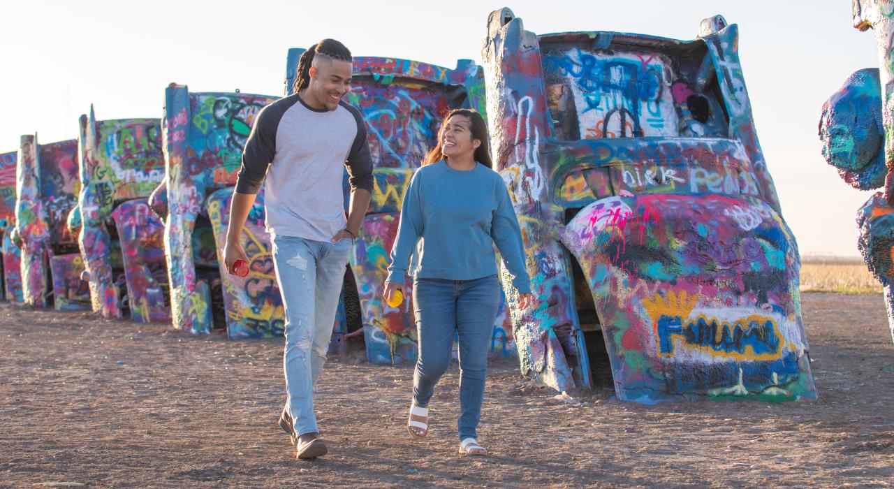 步行参观德克萨斯州阿马里洛凯迪拉克农场半掩埋的涂鸦轿车