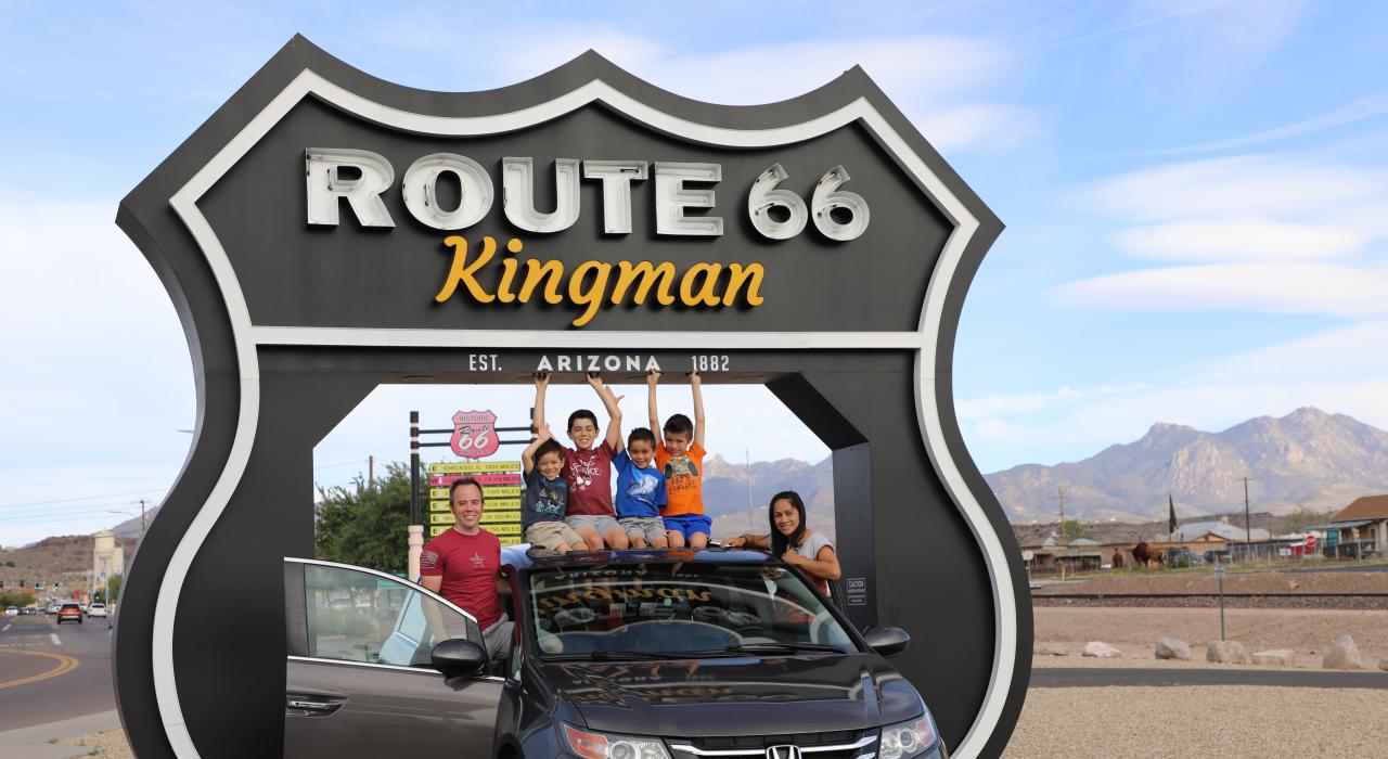 一家人在金曼游客中心的 Route 66 Drive-Thru Shield 景点前合影留念
