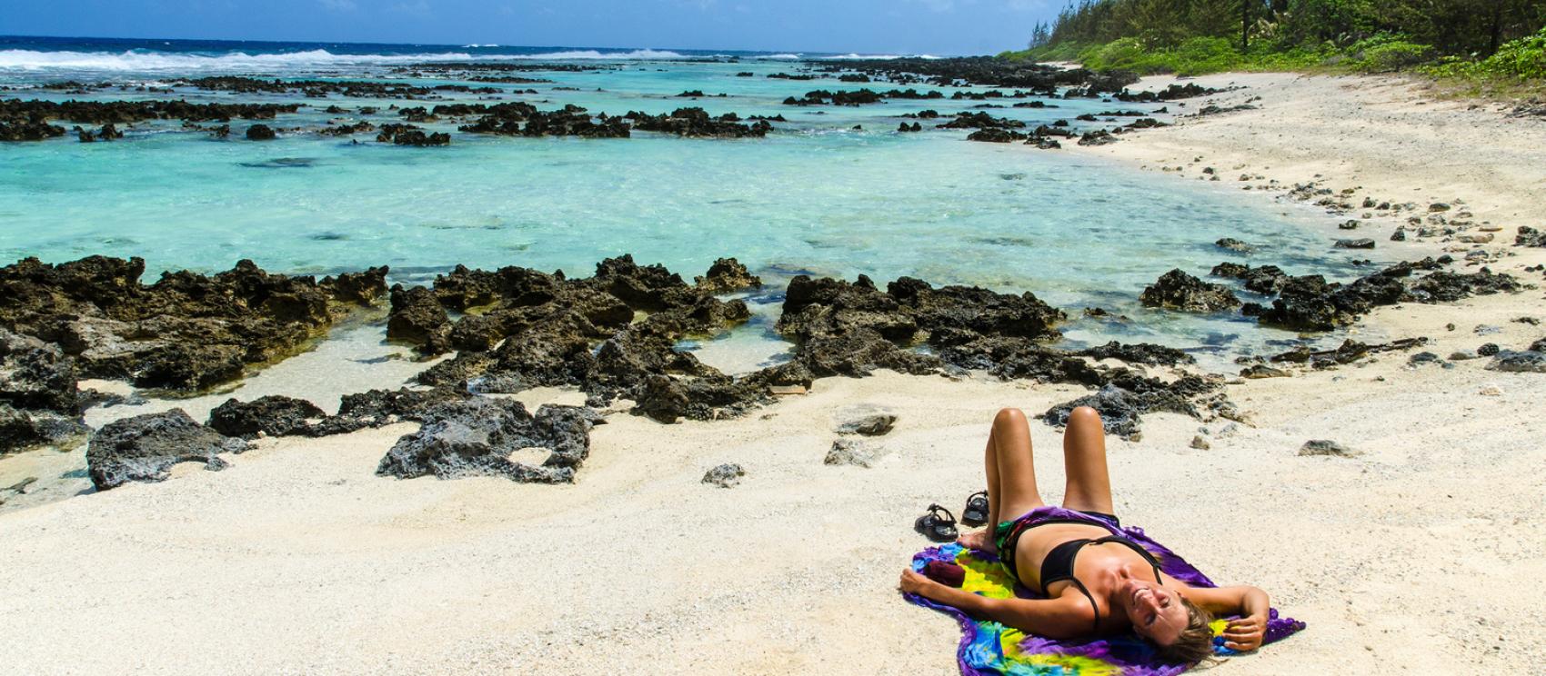 在崎岖的白沙海滩上尽享日光浴