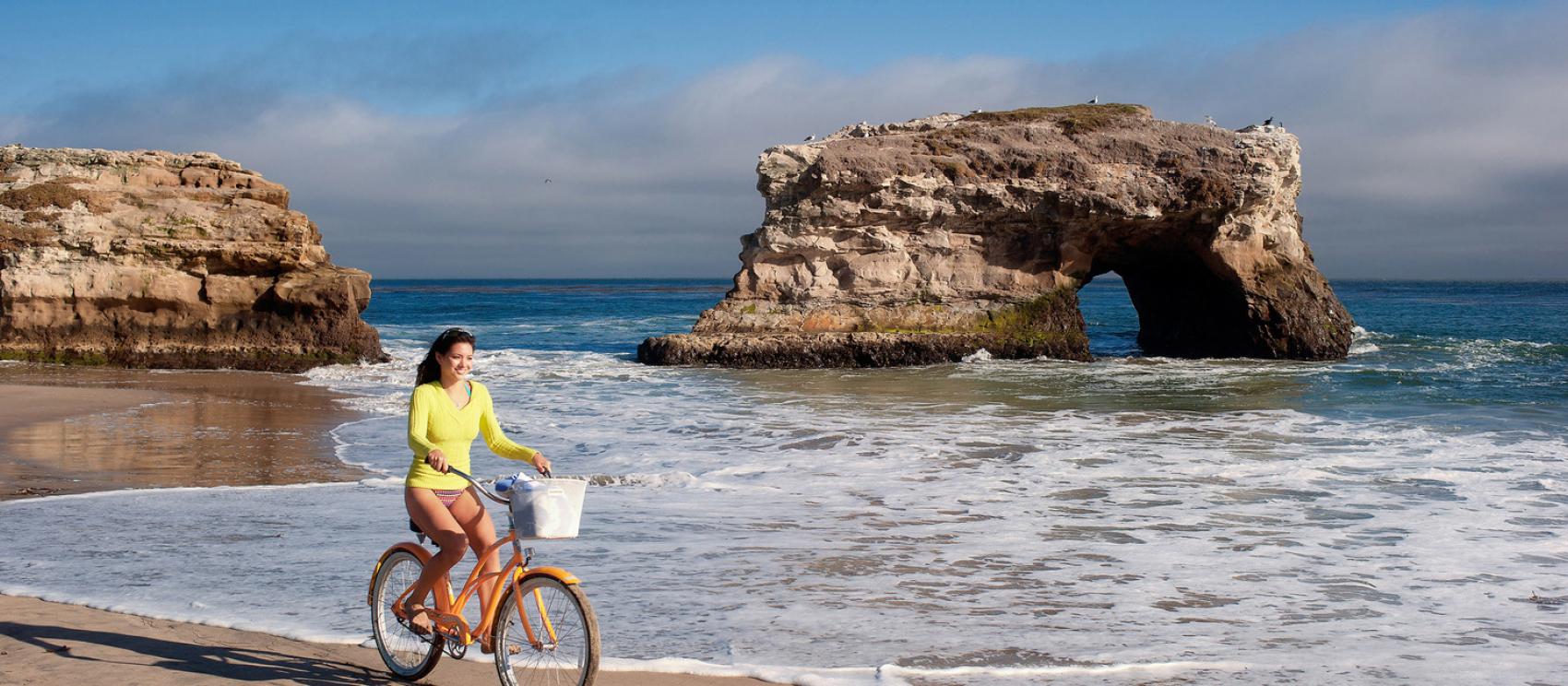 在圣克鲁斯的自然桥州立海滩骑自行车 在圣克鲁斯的自然桥州立海滩骑自行车